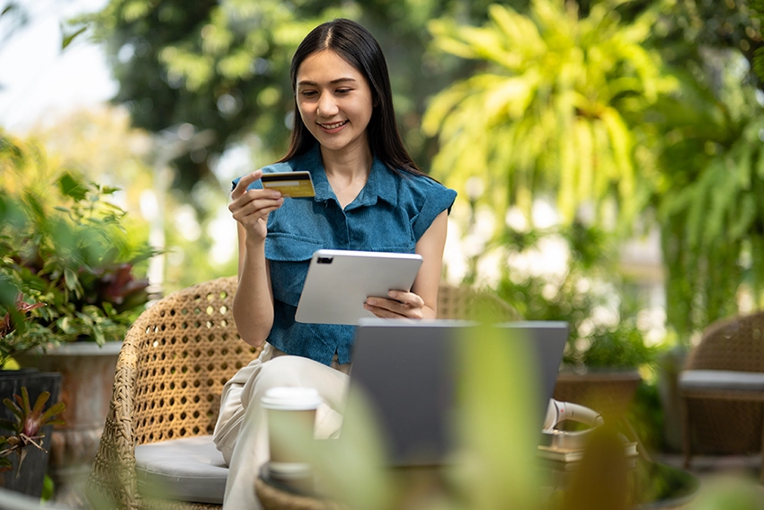 Femme tenant une carte de crédit et une tablette