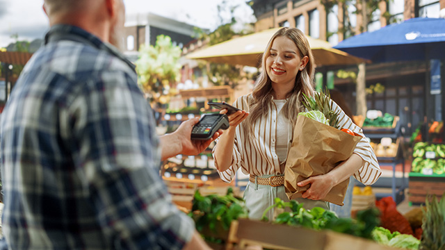 Woman paying for vegatables at a farmers market