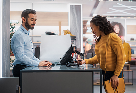 Woman checking out at a retail counter with her phone
