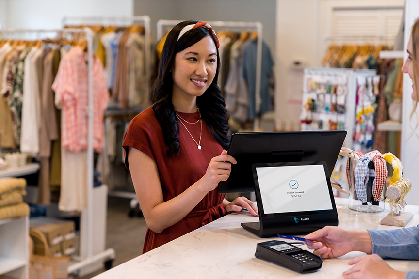 Woman behind counter at a clothing store accepting payment